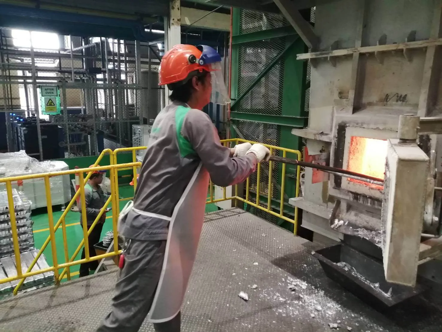 金属溶解炉で耐熱保護具を着用して作業する作業員